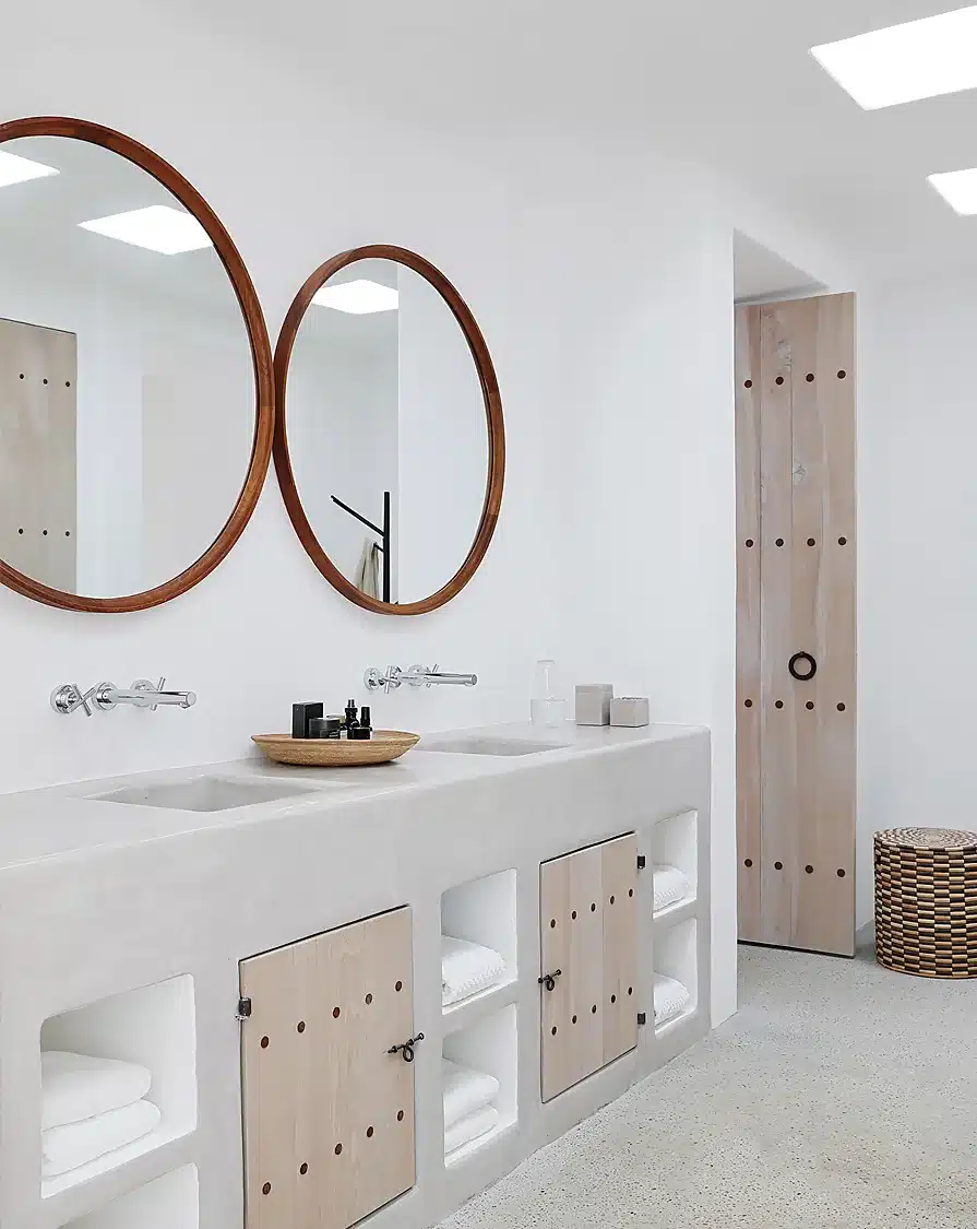 Baño-de-microcemento-con-muebles-de-esquinas-redondeadas-y-espejos-redondos.