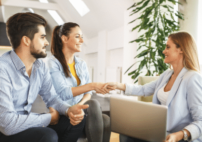 Agente inmobiliaria asesorando a una pareja para vender una propiedad