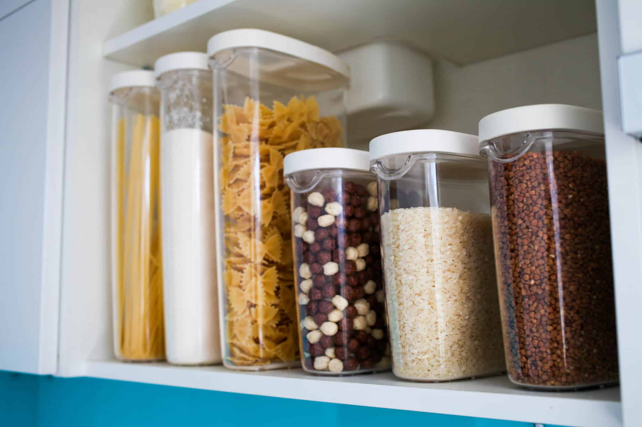 The organization and storage in kitchen of a case with grain in plastic containers.