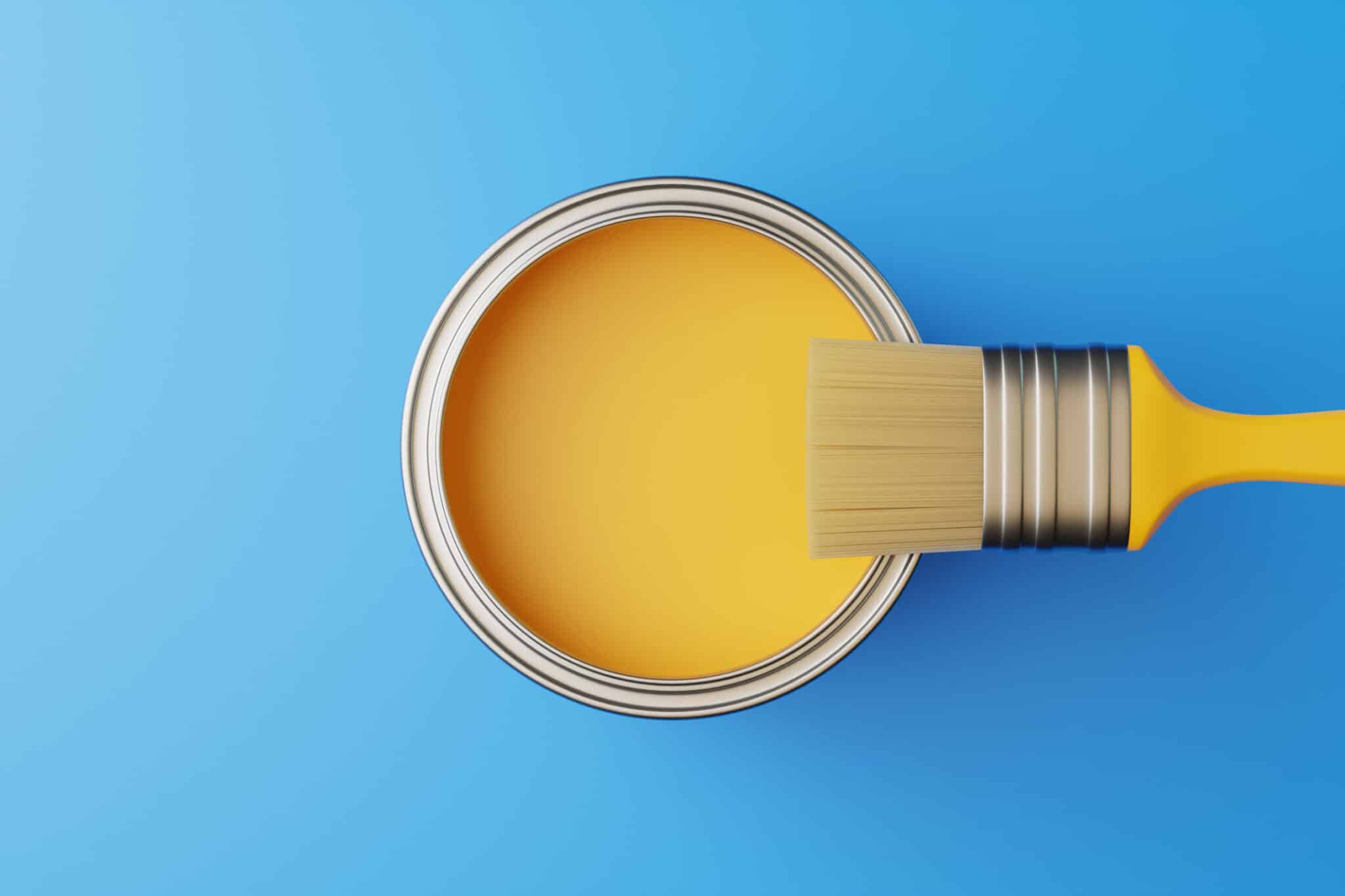An open can of paint and a brush on a blue background