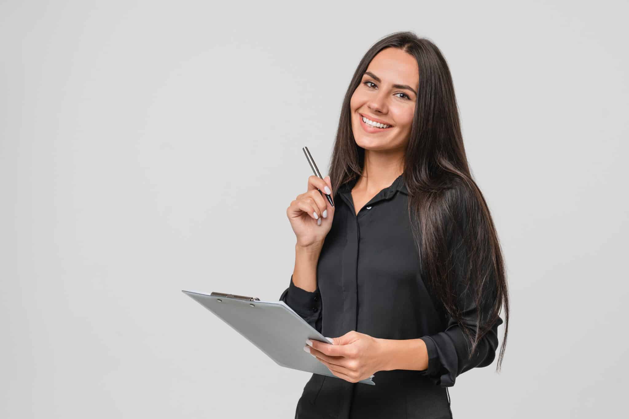 Smiling confident caucasian young businesswoman auditor writing on clipboard, signing contract document isolated in white background